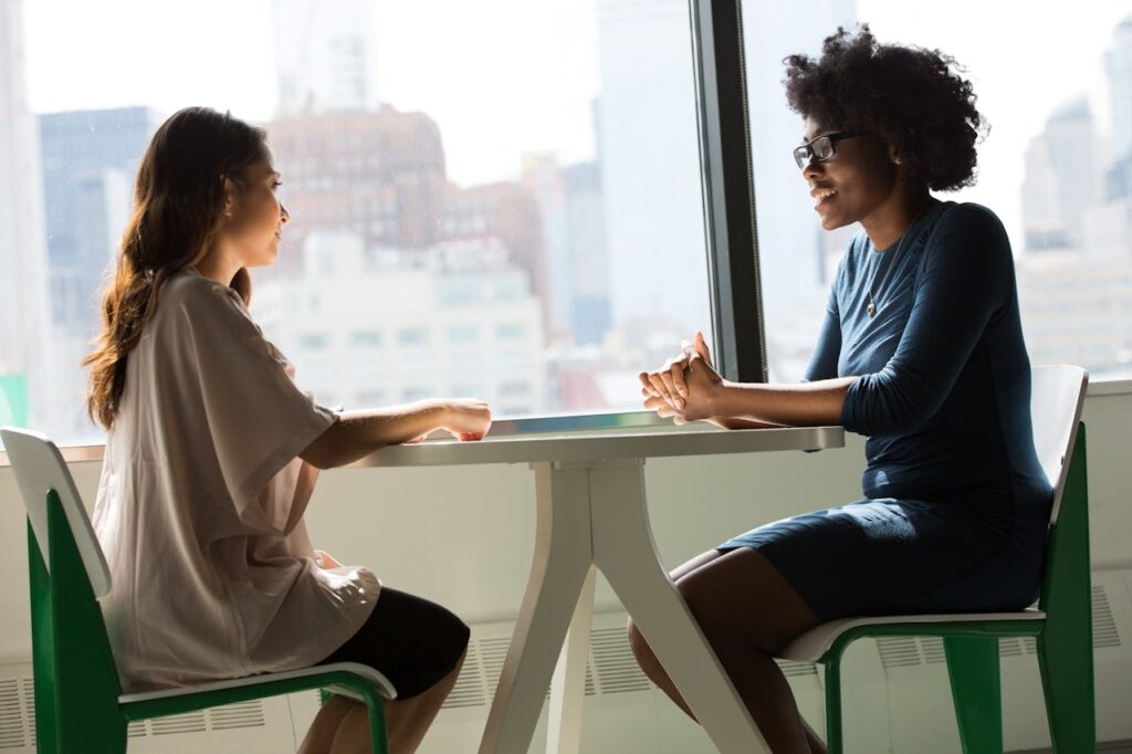 Due donne sedute su sedie accanto alla finestra